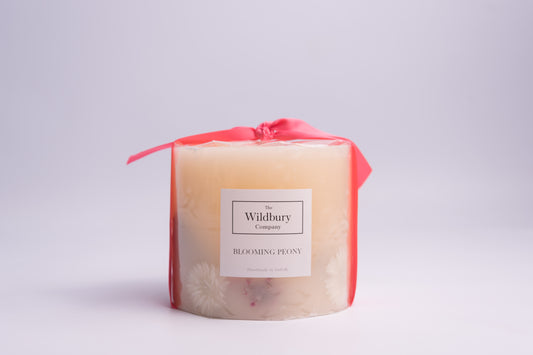 Blooming Peony Pillar Candle with Three Wicks. White Flowers pressed into the wax and pink ribbon