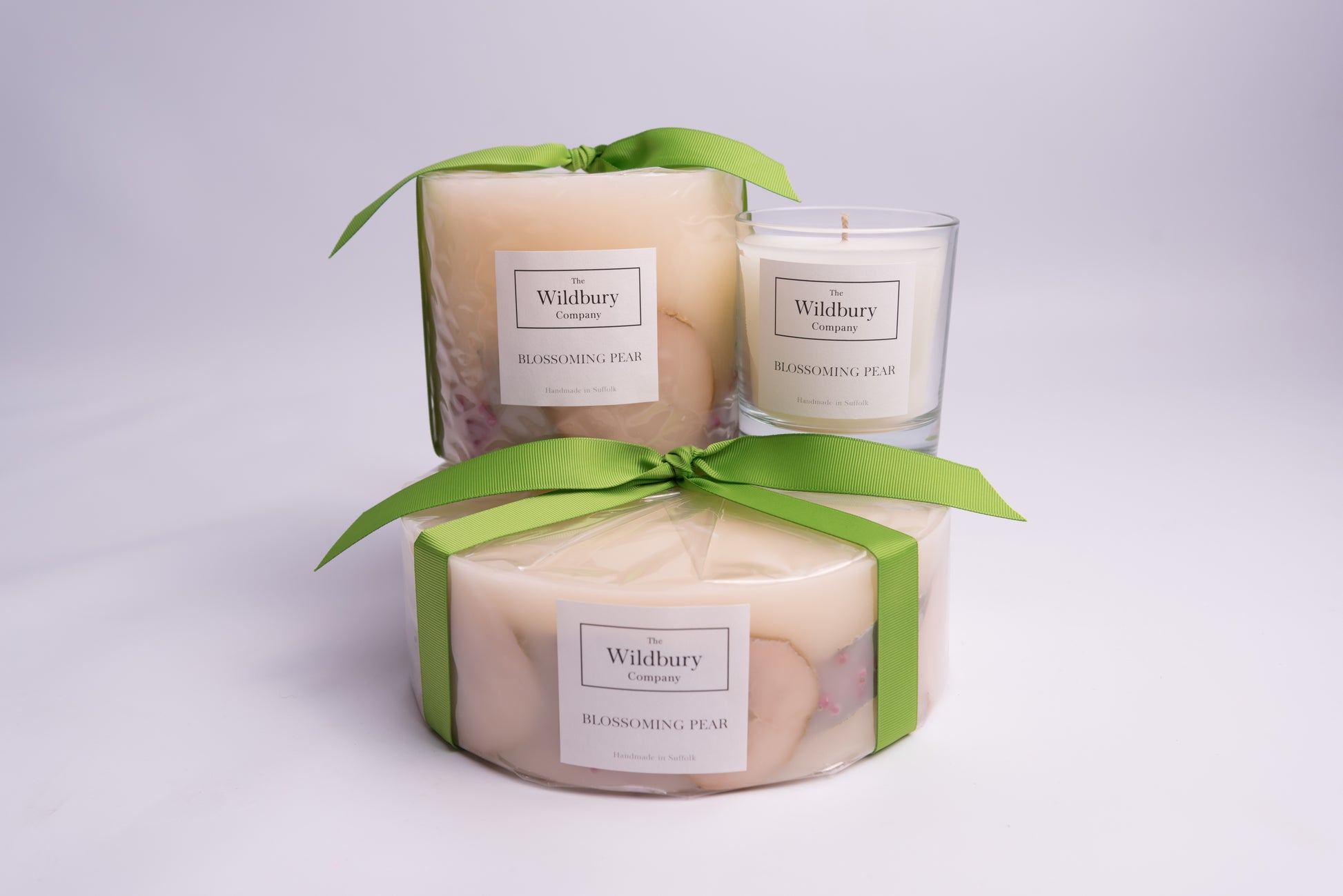 Collection of three candles, all in the fragrance Blossoming Pear layered on top of one another.