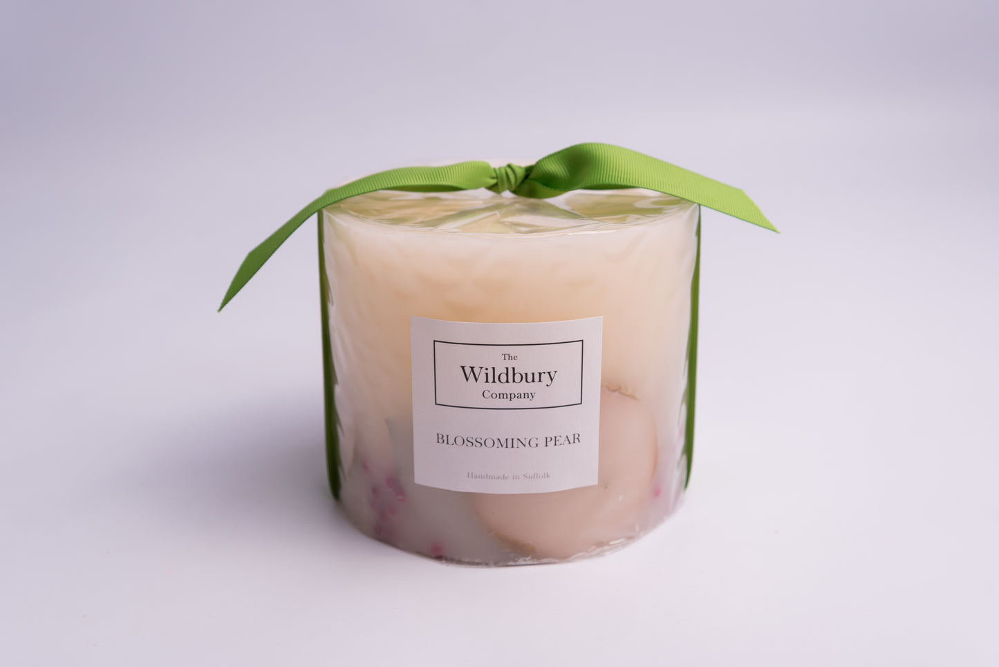 Large Three Wiick Botanical Candle with apple slices and berries carefully suspended within the hand-poured wax, Tied with a vibrant green ribbon.