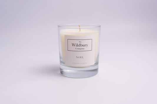 White Wax Single Wick Candle in Glass. With white label on the front of the glass.